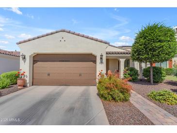 Charming home with a two-car garage, desert landscaping, and a tile roof under a blue sky at 14200 W Village Pkwy # 2128, Litchfield Park, AZ 85340