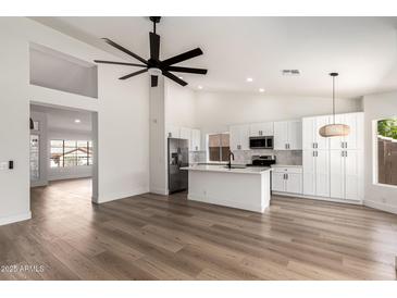 Open floor plan with high ceilings showcasing kitchen, living and dining areas at 15226 S 14Th Dr, Phoenix, AZ 85045