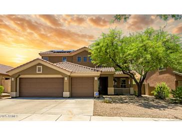Inviting two-story home featuring a three-car garage, desert landscaping, and a covered porch at 17493 W Arroyo Way, Goodyear, AZ 85338
