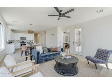 Bright and inviting living room with plush seating, modern ceiling fan, and open-concept design at 2755 N 103Rd Ave, Avondale, AZ 85392