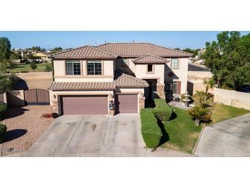 Two-story home with a three-car garage, desert landscaping and well-maintained lawn at 7102 W Pueblo Ave, Phoenix, AZ 85043