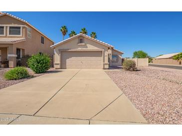 Charming single-story home with a two-car garage, desert landscaping, and sunny skies at 15440 W Mauna Loa Ln, Surprise, AZ 85379