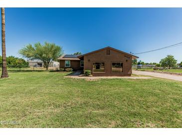 Charming single story home with solar panels, desert landscaping and a large grassy front yard at 19302 W Melvin St, Buckeye, AZ 85326