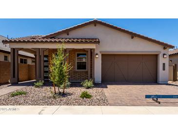 Charming home featuring a brick facade, desert landscaping, and a spacious two-car garage at 19338 S 212Th Pl, Queen Creek, AZ 85142