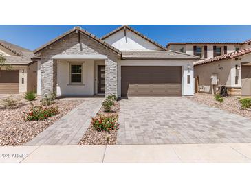 Charming single-story home featuring stone accents, a two-car garage, and beautiful desert landscaping at 19434 S 212Th Pl, Queen Creek, AZ 85142