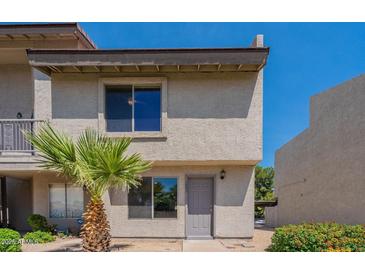 Charming two-story townhouse with desert landscaping and a gray front door at 19601 N 7Th St # 1003, Phoenix, AZ 85024