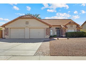 Charming single-story home featuring a tile roof, two-car garage, and low-maintenance gravel landscaping at 20352 N 109Th Dr, Peoria, AZ 85373