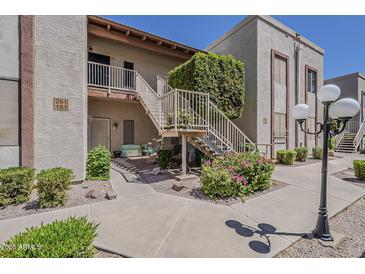 Inviting condo exterior with lush landscaping, stairway, and a charming bicycle display at 205 N 74Th St # 261, Mesa, AZ 85207