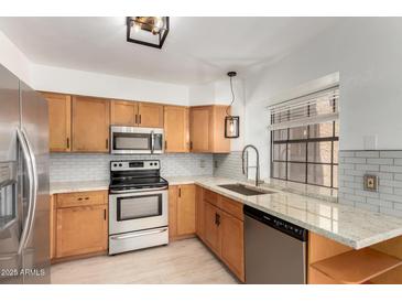 Bright kitchen features stainless steel appliances, granite countertops and wooden cabinetry at 4901 E Kelton Ln # 1251, Scottsdale, AZ 85254