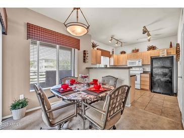 Cozy dining area with modern light fixture, seating for four, and views to the kitchen at 7401 W Arrowhead Club Dr # 2067, Glendale, AZ 85308