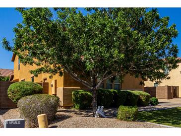 Charming home featuring lush landscaping, manicured bushes, and a shade tree in front yard at 3080 E Andre Ave, Gilbert, AZ 85298