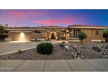 Charming home featuring desert landscaping, two car garage and stone accents enhancing the curb appeal at 42105 N Golf Crest Rd, Anthem, AZ 85086