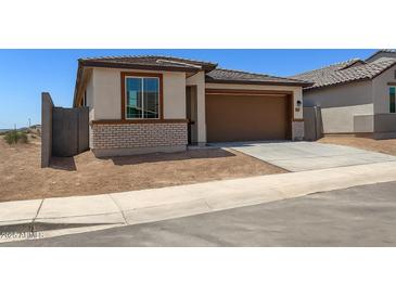 Charming single-story home featuring a two-car garage and a brick facade with desert landscaping at 5650 S 253Rd Ave, Buckeye, AZ 85326