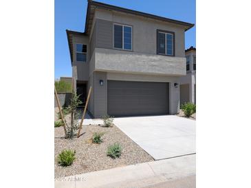 Charming two-story home featuring a gray exterior, concrete driveway, and an attached two-car garage at 9366 E Sequence Ave, Mesa, AZ 85212