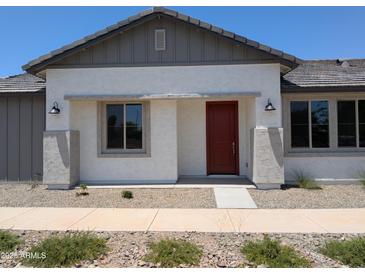 Charming single-story home featuring a stucco exterior, a red front door, and well-kept landscaping at 9416 E Sequence Ave, Mesa, AZ 85212