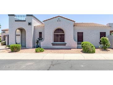 Charming home featuring a stucco exterior, arched entryway, and a well-maintained front yard at 16803 N 49Th Way, Scottsdale, AZ 85254