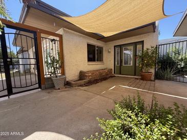 Charming front yard patio with mature plants and a shade covering the entrance to the house at 1725 N Date -- # 8, Mesa, AZ 85201