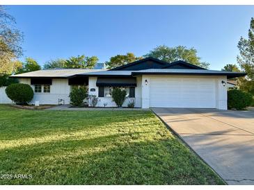 Charming single-story home featuring a well-manicured lawn and a two-car garage at 1742 W Butler Dr, Phoenix, AZ 85021