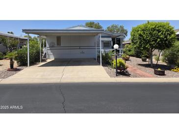 Charming mobile home features a covered carport and beautifully landscaped surroundings at 2233 E Behrend Dr # 17, Phoenix, AZ 85024
