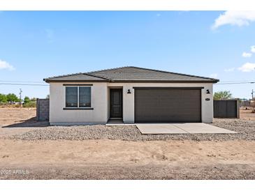 Charming single-story home featuring a neutral stucco finish, a gray garage door, and desert landscaping at 3105 W Romana Dr, Eloy, AZ 85131
