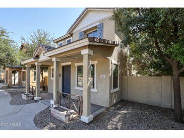 Charming two-story home featuring a welcoming front porch and neutral color palette at 813 E Agua Fria Ln, Avondale, AZ 85323