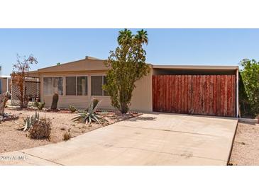 Charming home with desert landscaping and a wooden gated carport at 9347 E Edgewood Ave, Mesa, AZ 85208