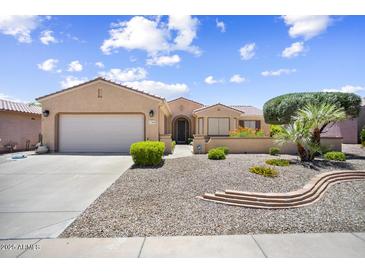 Charming home with a well-maintained desert rock front yard and a two-car garage at 17009 W Eureka Springs Dr, Surprise, AZ 85387