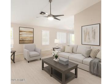 Bright living room featuring a ceiling fan, modern furnishings, neutral color palette, and large decorative artwork at 19206 N 40Th St, Phoenix, AZ 85050