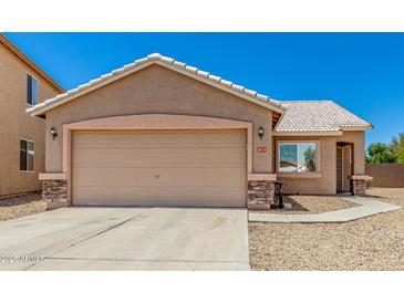 Home exterior featuring a two-car garage, gravel landscaping, and a tiled roof at 2018 N 104Th Dr, Avondale, AZ 85392