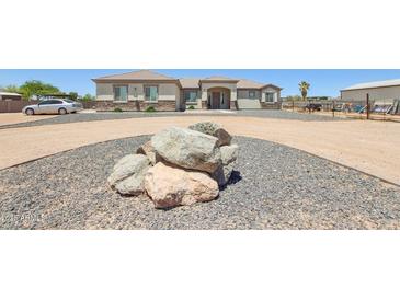 Charming single-story home showcasing rock accents, gravel landscaping, and a circular driveway at 28156 N Edwards Rd, San Tan Valley, AZ 85143