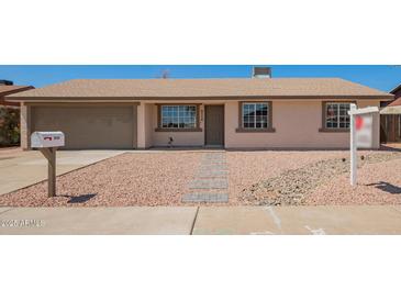 Charming single-story home with a neutral color scheme, low-maintenance rock landscaping and a two car garage at 3114 W Villa Maria Dr, Phoenix, AZ 85053