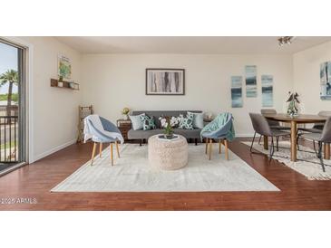 This is a living room and dining room combo with wood floors, a decorative rug, and neutral decor at 740 W Elm St # 266, Phoenix, AZ 85013