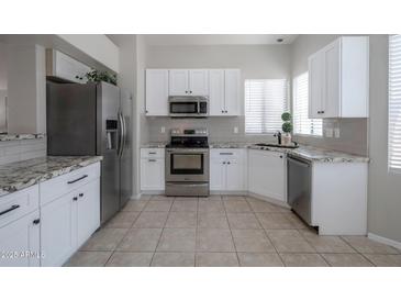 Bright kitchen features stainless steel appliances, white cabinets, and granite countertops at 839 W Silver Creek Rd, Gilbert, AZ 85233