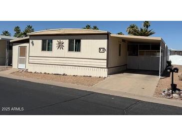 Tan home in a landscaped community with a covered parking area, desert landscaping and a low-maintenance yard at 9501 E Broadway Rd # 68, Mesa, AZ 85208