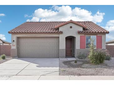 Charming single-story home with a tile roof, two-car garage, neutral stucco, and tasteful landscaping at 15611 W Hackamore Dr, Surprise, AZ 85387