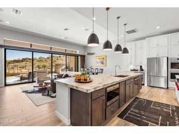 Stunning kitchen with a large island, stainless steel appliances, and an open floor plan leading to a cozy living room at 16134 E Ridgestone Dr, Fountain Hills, AZ 85268