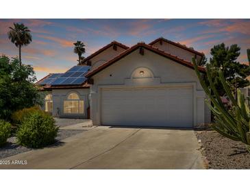 Charming single Gathering home with a two car garage, solar panels, and desert landscaping at 7108 W Morrow Dr, Glendale, AZ 85308