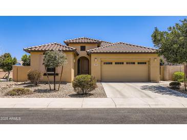 Charming single-story home featuring a tile roof, desert landscaping, and a two-car garage at 7665 W Fetlock Trl, Peoria, AZ 85383
