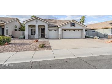 Charming single-story home featuring a three-car garage and low maintenance desert landscaping at 1584 E Harrison E St, Chandler, AZ 85225