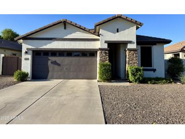 Charming one-story home featuring a gray garage door, stone accents, and low maintenance landscaping at 2715 E Canyon Creek Dr, Gilbert, AZ 85295