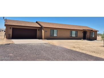 Single story home showcasing a two-car garage and a desert landscape at 31515 W Buchanan St, Buckeye, AZ 85326