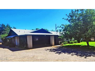 Spacious property with a covered parking area, lush landscaping, and a well-maintained lawn at 5016 W Sunrise Dr, Laveen, AZ 85339