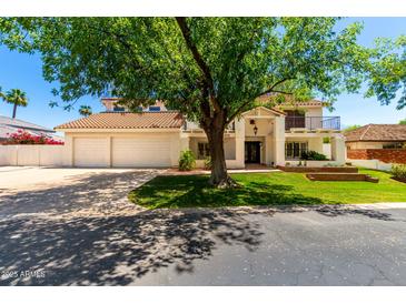 Stunning two-story home with a Spanish tile roof, a three-car garage, and mature landscaping at 119 E Palomino Dr, Tempe, AZ 85284
