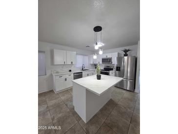 Modern kitchen featuring white cabinets, stainless steel appliances, and center island with pendant lighting at 13606 N 130Th Ave, El Mirage, AZ 85335