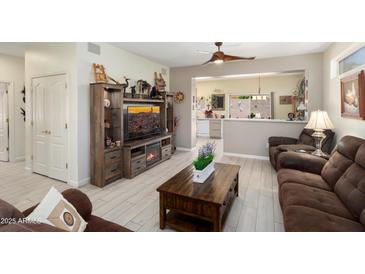 Inviting living room features a decorative entertainment center, hardwood floors and natural lighting at 15790 W Arrowhead Dr, Surprise, AZ 85374