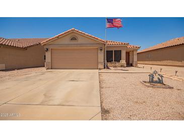 Charming single-story home with a two-car garage and well-kept desert landscaping, flying an American flag at 2202 S Lawther Dr, Apache Junction, AZ 85120
