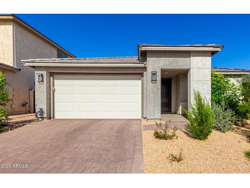Modern home featuring a two-car garage, desert landscaping, and a neutral color palette under a clear blue sky at 32611 N 20Th Dr, Phoenix, AZ 85085