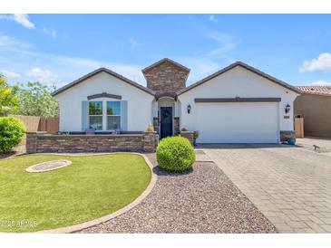 Charming single-story home featuring a well-manicured lawn, stone accents, and a welcoming two-car garage at 35701 N Bandolier Dr, San Tan Valley, AZ 85144