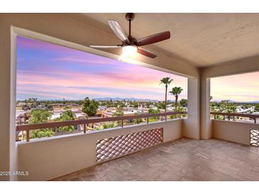 Enjoy city views from this balcony with tile flooring and decorative partition, illuminated by a ceiling fan at 4200 N Miller Rd # 504, Scottsdale, AZ 85251