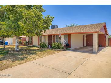 Charming single-story home with a concrete driveway and a well-maintained lawn and mature tree at 5343 W Coronado Rd, Phoenix, AZ 85035